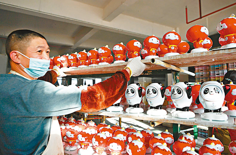 ◆在泉州德化縣陶瓷旅遊觀光工廠，工人擺放製作好的「冰墩墩」、「雪容融」。