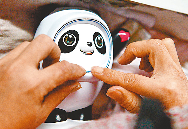 ◆工人給「冰墩墩」貼花紙。