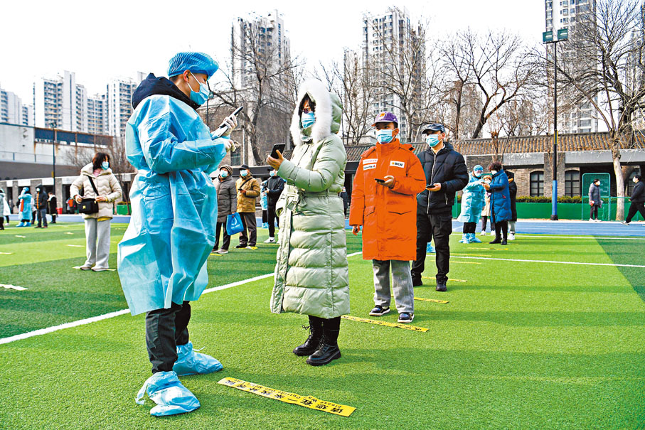 ◆在內地核酸檢測點，工作人員通過手機掃碼為待檢測居民錄入信息。  資料圖片