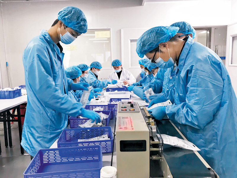 ◆廣東和信健康科技有限公司員工為抗原快檢套裝的出貨忙碌。圖為該公司裝配車間工人正在作業。 香港文匯報記者敖敏輝  攝