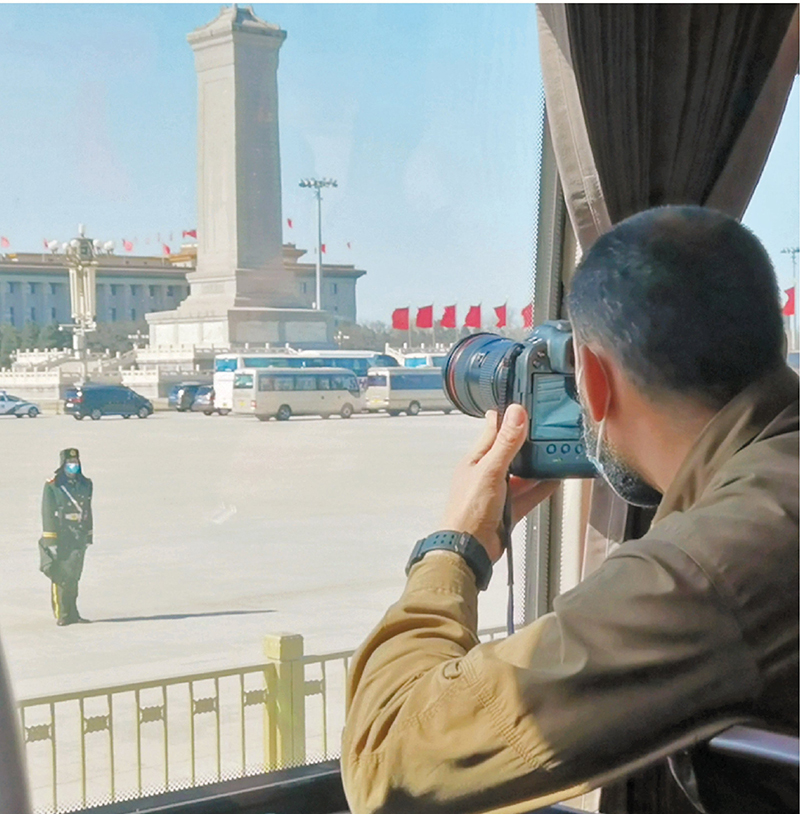 ◆外國記者在大巴上拍攝人民大會堂外景。 香港文匯報記者朱燁  攝