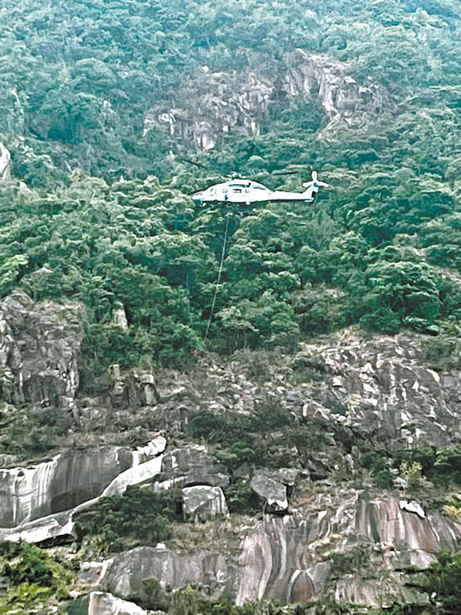 ◆政府飛行服務隊一架直升機在山頂盧吉道對落約100米山崖吊起女死者遺體。 網上圖片