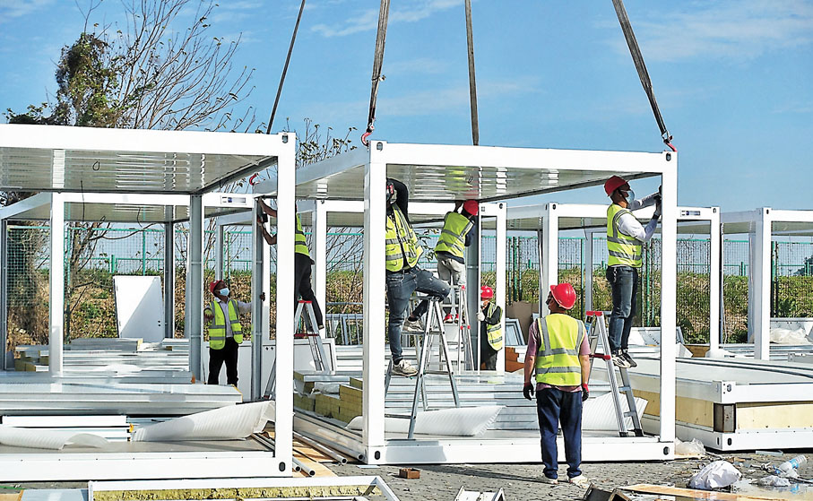 ◆烈日下，工作人員在碼頭專門開闢的場地上搭建方艙活動房屋。香港文匯報記者盧靜怡 攝