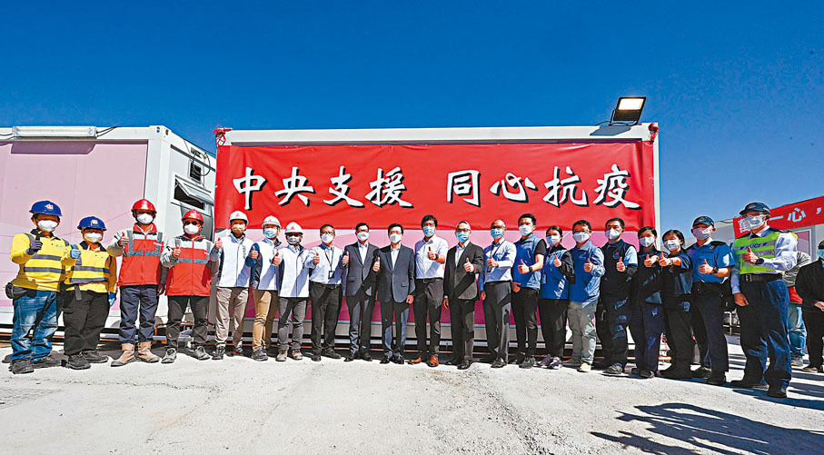 ◆多名政府官員昨日參觀新田方艙醫院設施後，與在場工作人員合照。