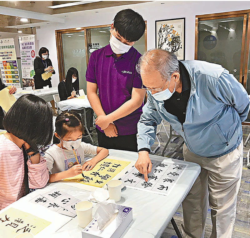 ◆梁君度為參與活動的青少年講解書法知識。 受訪者供圖