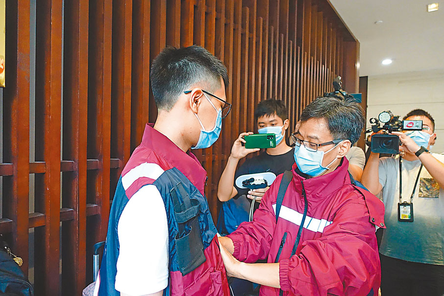 ◆領隊張忠德為隊員貼上醫院的識別標誌。香港文匯報記者盧靜怡 攝