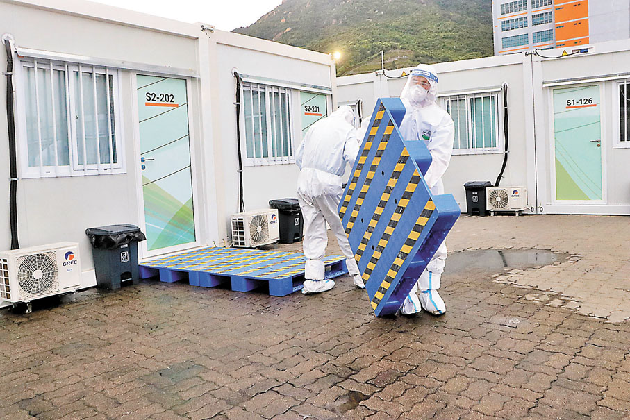 ◆維修保養人員在水浸區鋪設防滑踏板，讓住戶能順利前往廁所等功能性貨櫃。 香港文匯報記者  攝