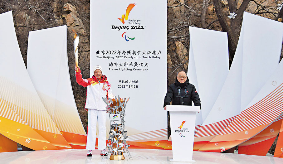 ◆火炬手夏伯渝（左）展示點燃的城市火種火炬。 新華社