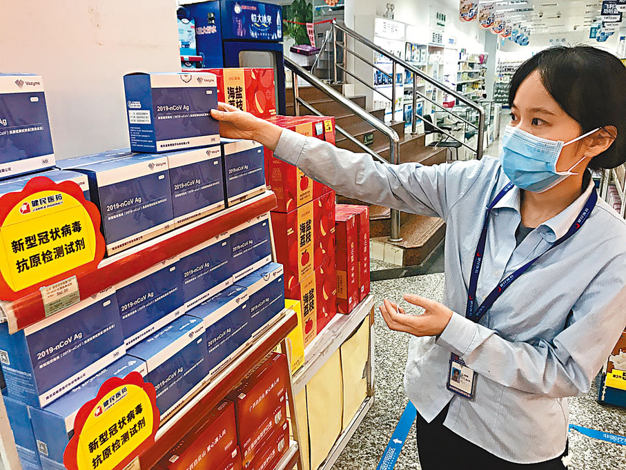 ◆藥店店員介紹新到貨的新冠抗原檢測產品。 香港文匯報記者敖敏輝  攝