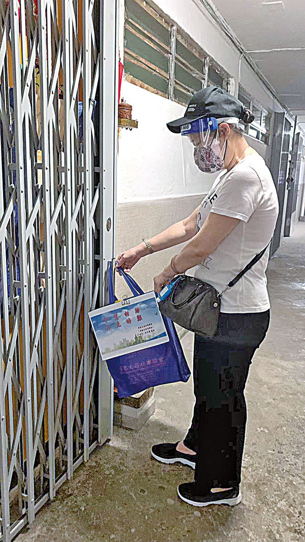 ◆ 義工團出動為有需要市民送去物資，副團長李貞（上圖）、符玲（下圖）將物資放置於市民門口。