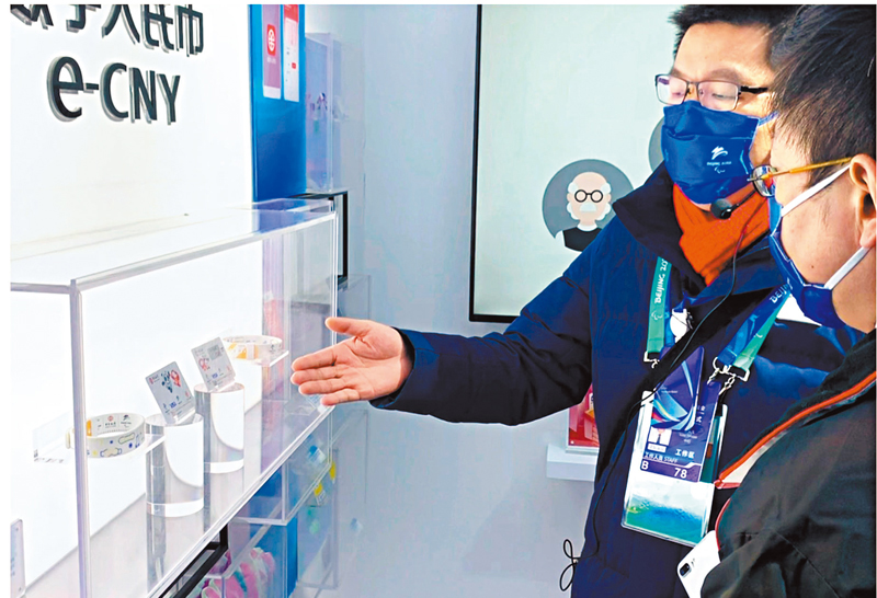 ◆工作人員介紹數字人民幣實體介質錢包「冰芯」和「雪環」。 記者凱雷  攝