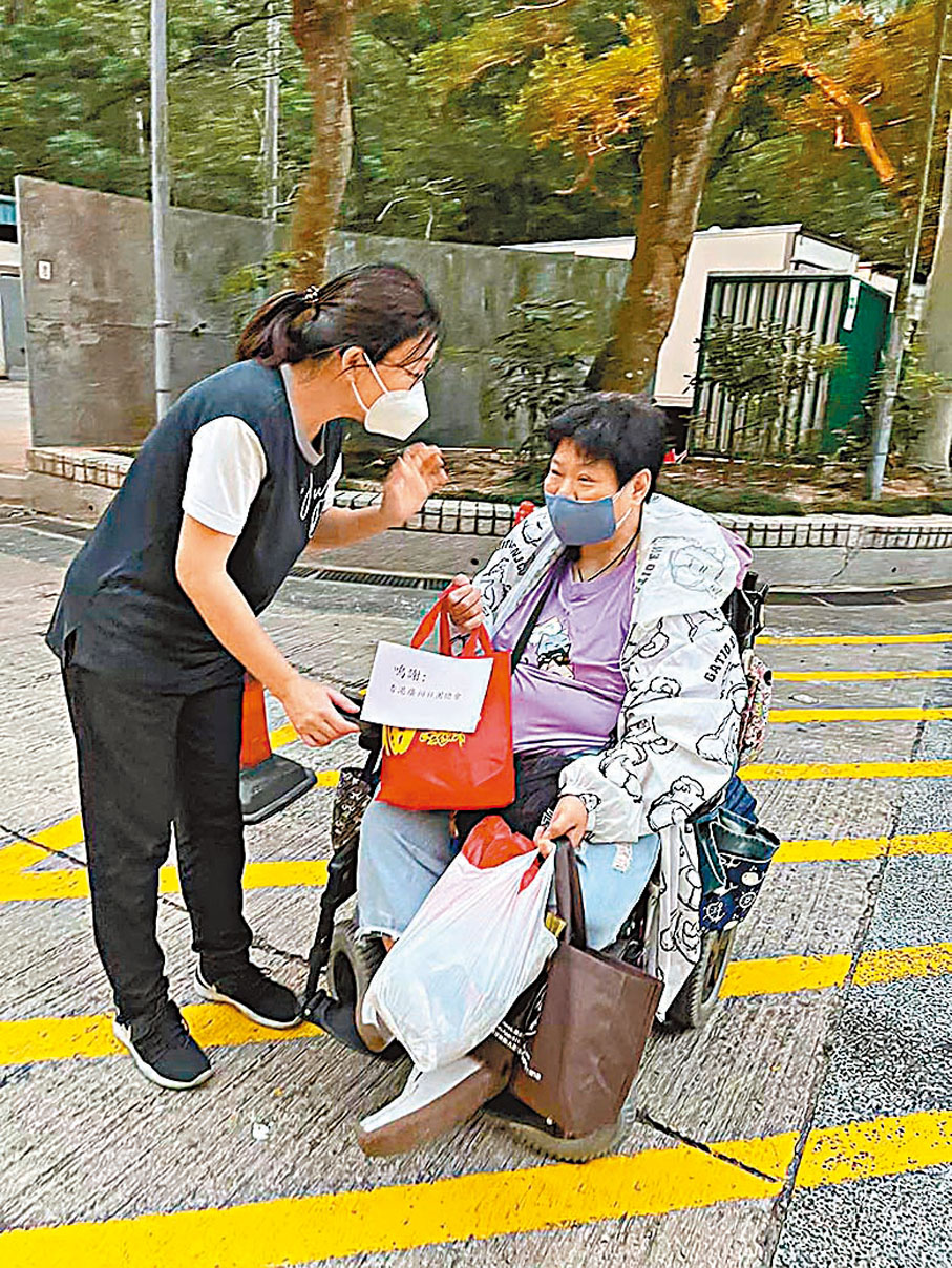 ◆陳敏娟（左）向行動不便街坊派發防疫物資。受訪者供圖