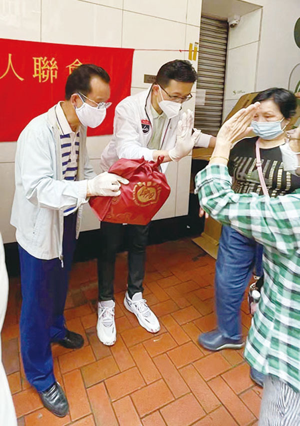 ◆ 香港工聯會會長、立法會議員吳秋北（左二）和香港區潮人聯會會長胡池（左一）向街坊派口罩。