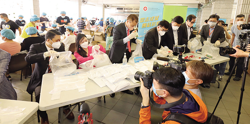 ◆ 陳積志與廣總首長及多名立法會議員在荃灣官立中學參與包裝工作。