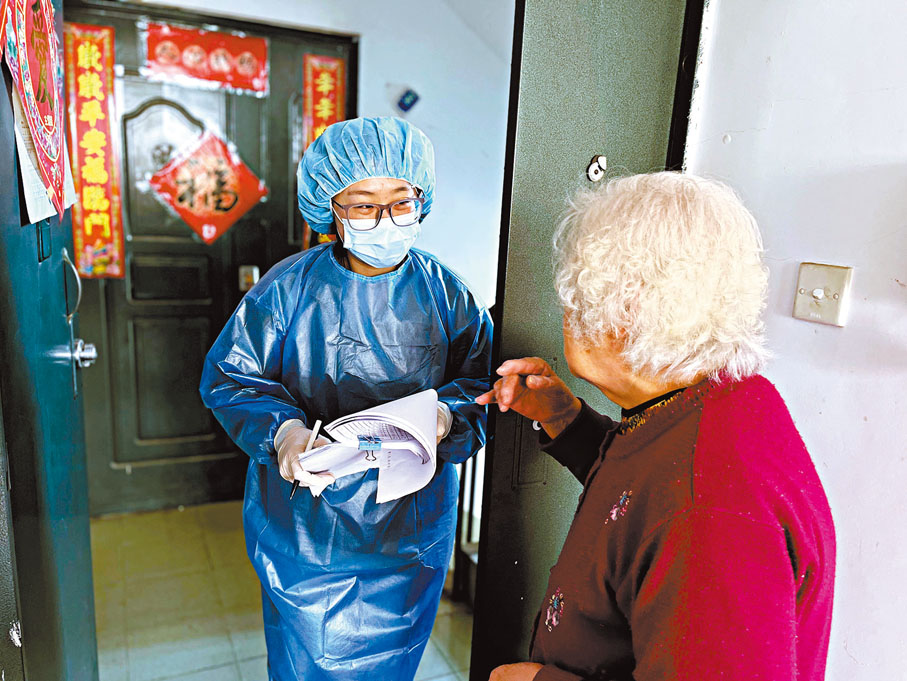 ◆ 上海一封控區內，社區工作人員在記錄長者居民的需求。 新華社