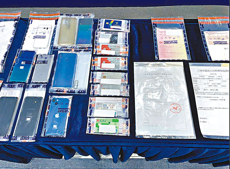 ◆警方在騙徒住所檢獲電話、偽造文件及提款卡等證物。 警方圖片