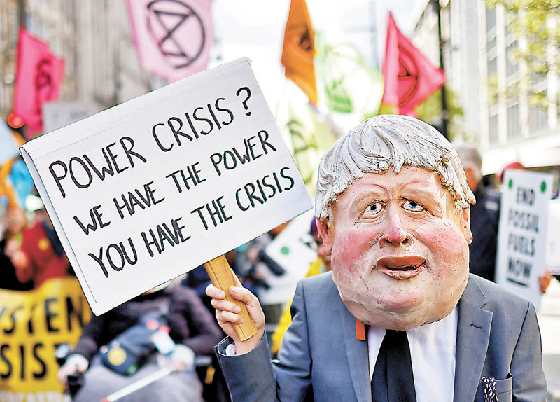 ◆英國民眾手持寫有「能源危機？我們有權力（英文中與能源同作Power），你們有危機」的標語。 法新社