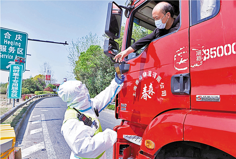 ◆上海市高速公路11日起臨時設5處貨櫃運輸車輛專用服務區，對服務於上海港的貨櫃車在本市高速公路實行閉環管理。圖為民警查驗司機核檢證明。 中新社