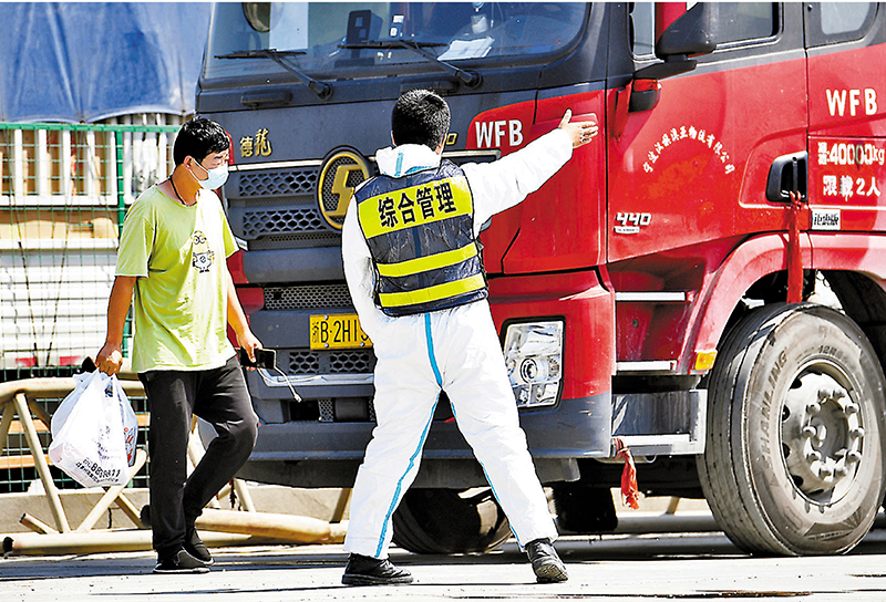 ◆浙江杭州農副產品物流中心日前對外地來杭送貨車輛實行接駁機制。圖為工作人員引導外地來杭貨車司機前往臨時隔離區休息。 中新社