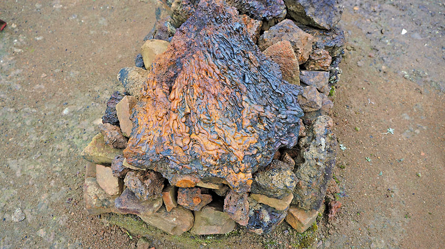 ◆遺址前堆放宋元時期冶鐵後的扇狀鐵渣。考古工作者正是發現這類鐵渣判定遺址所在區域存在冶煉爐。