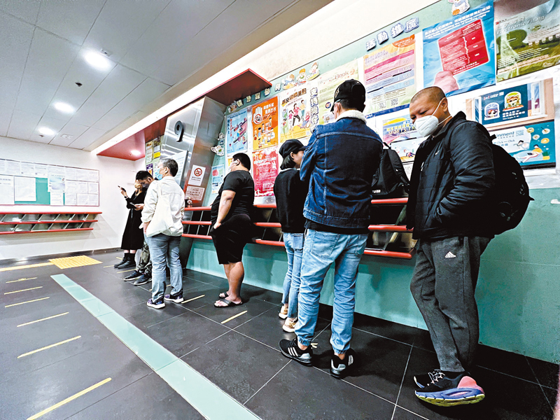 ◆檔位競投會上，右方3人在排隊時不斷交談，其中戴鴨舌帽女子其後以26.5萬元投得赤柱海濱小食亭1號攤檔。香港文匯報記者 攝