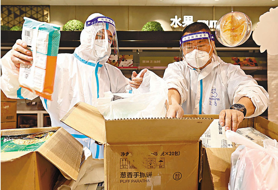 ◆杜順（右）和同樣來自武漢的同事一同裝貨。 新華社