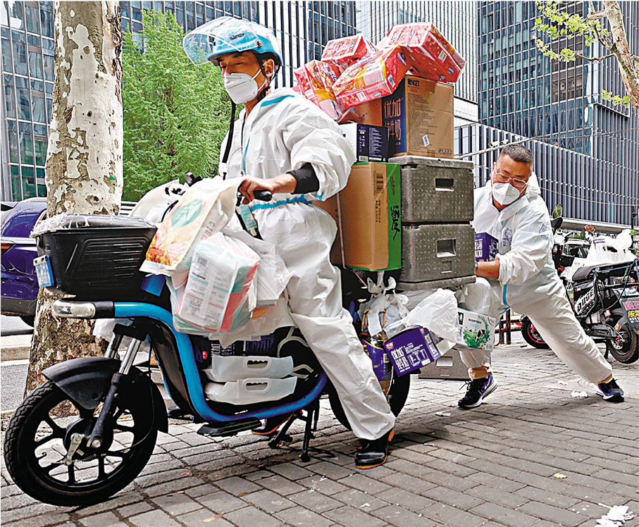 ◆盒馬鮮生武漢帝斯曼店副店長杜順（右）增援上海。圖為杜順幫助送貨員啟動送貨車。 新華社