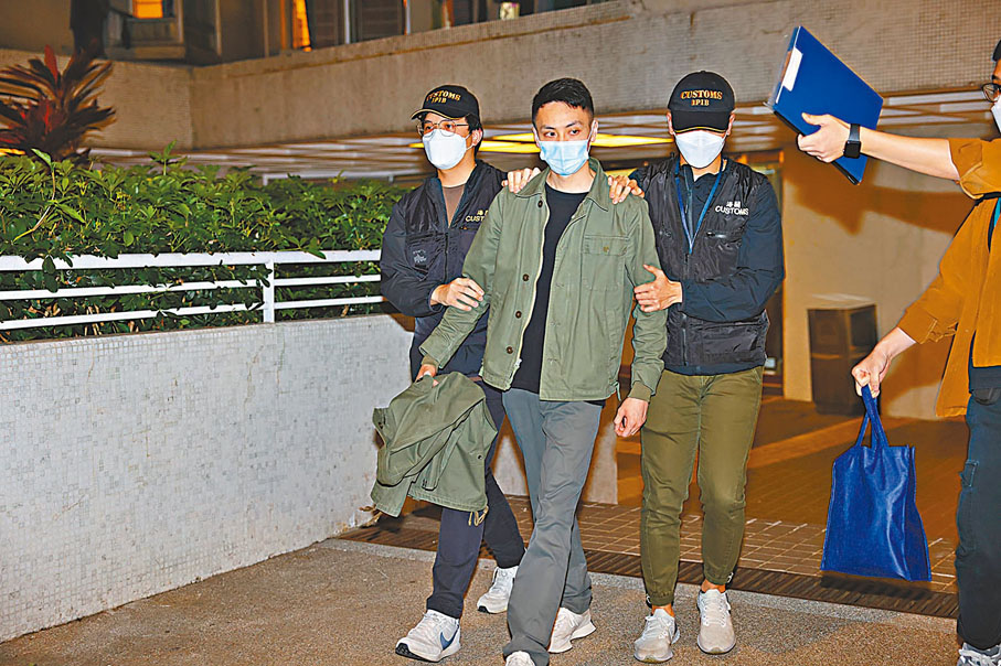 ◆海關昨晚在鰂魚涌康山花園拘捕涉嫌干犯商品說明條例的男子（左二）。香港文匯報記者  攝