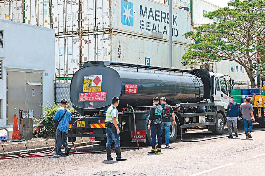 ◆執法人員於檢獲用作非法入油活動被扣查的油缸車進行蒐證。 香港文匯報記者  攝