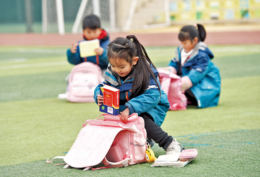 ◆老師提醒學生明天要帶什麼時，因為事情還未做，所以remember後面要用to。圖為學生在收拾書包。資料圖片