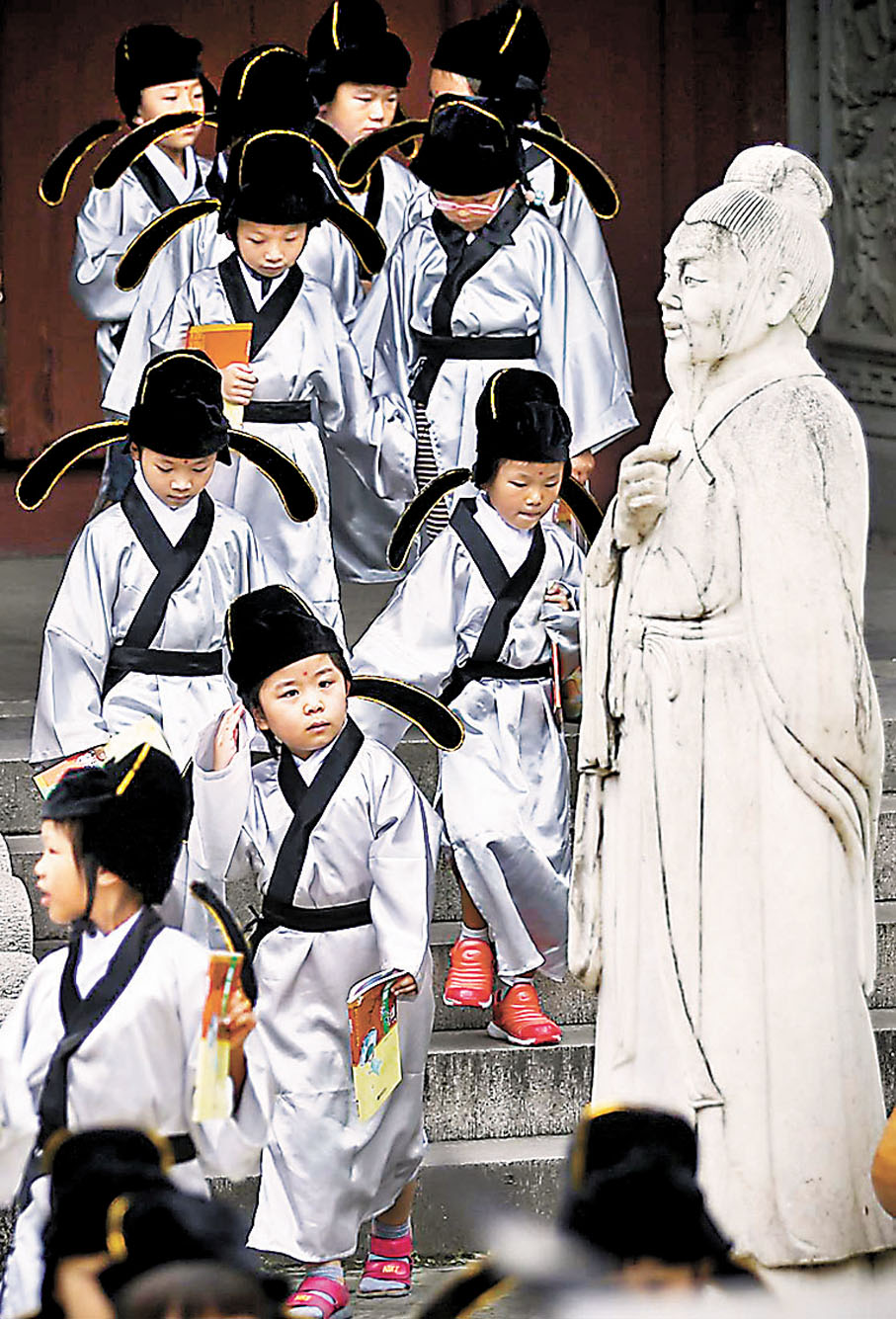 ◆ 孔子一生推廣仁愛思想，講學授徒，將自己的理想傳揚後世，因此被歷代尊為萬世師表，影響深遠。圖為南京小學生在孔子像前舉行「開筆破蒙」典禮。 資料圖片