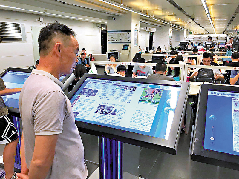 ◆《2021年度中國數字閱讀報告》認為，國民閱讀的行為和閱讀習慣正在向數字化轉型。圖為廣州市民在圖書館閱讀電子報刊。 香港文匯報記者敖敏輝  攝