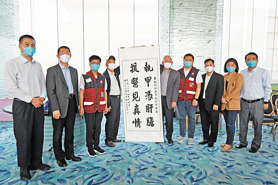 ◆獅子山文藝協會主席李堃銘（右三）、會長梁君度（中）、常務副會長方平（左二）、書畫委員會主任容可權（左四）四人，將作品「執甲憑肝膽    援醫見真情」贈予內地援港醫療隊，代表了香港一班藝術家對他們的一份敬意，醫療隊總領隊崇雨田（右四）、副總領隊張忠德（左三）、廣東省衞健委處長馮宏祥（左一）、副領隊李勇（右一）及廣東省港澳辦處長邵瑾女士代表接受。