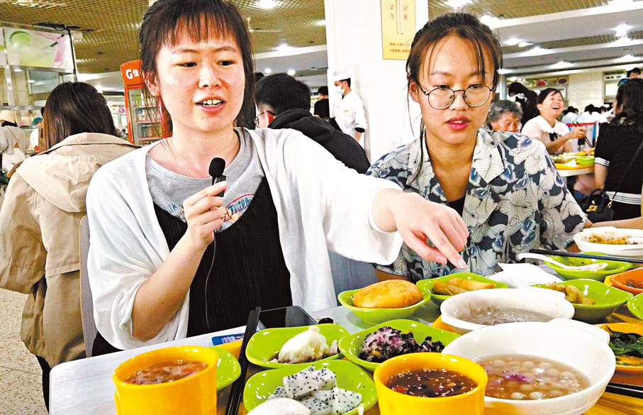 ◆來自山東的小劉同學為外地同學們推薦「玫瑰宴」中的菜品 。 香港文匯報記者譚旻煦 攝
