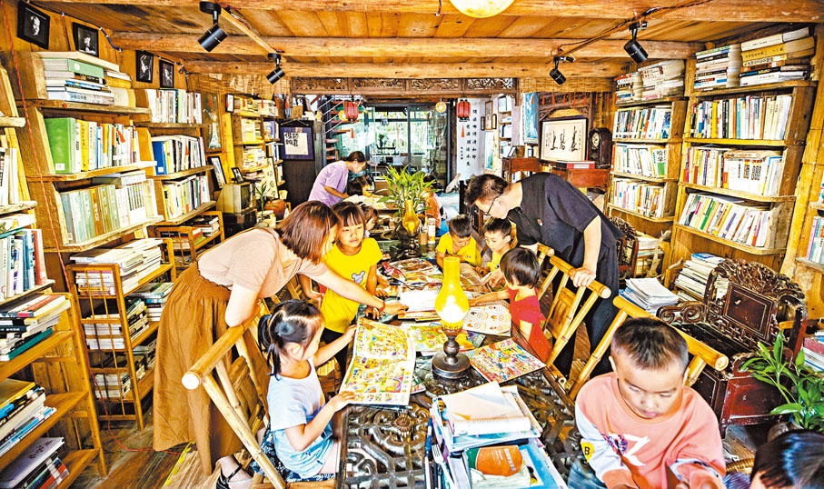 ◆戚玉龍（後右）給小朋友講解繪本圖書的內容。