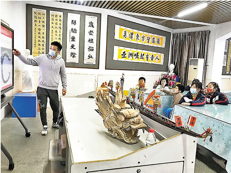 ◆張偉潮在廣州黃埔區夏園小學給孩子普及龍舟習俗以及龍頭龍尾製作技藝。