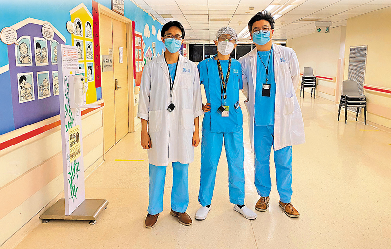 ◆周啟明醫生(中)難忘確診病人似海嘯式入院的那個晚上，已落班的眼科及視覺科學學系副顧問醫生甘嘉維(右)及副顧問醫生麥雋愉(左)請纓幫手收症。