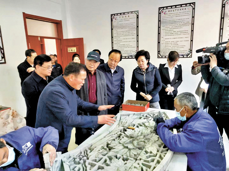 ◆卜文俊（左一）指導雕刻工人。