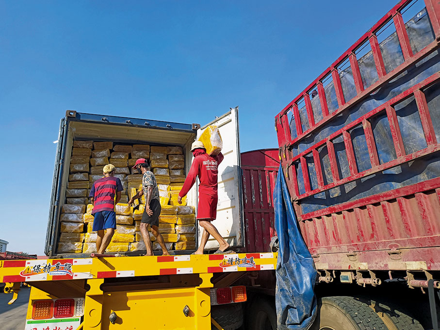 ◆ 老撾工人將要通過中老鐵路運往中國的貨品裝車。  雲南傳真