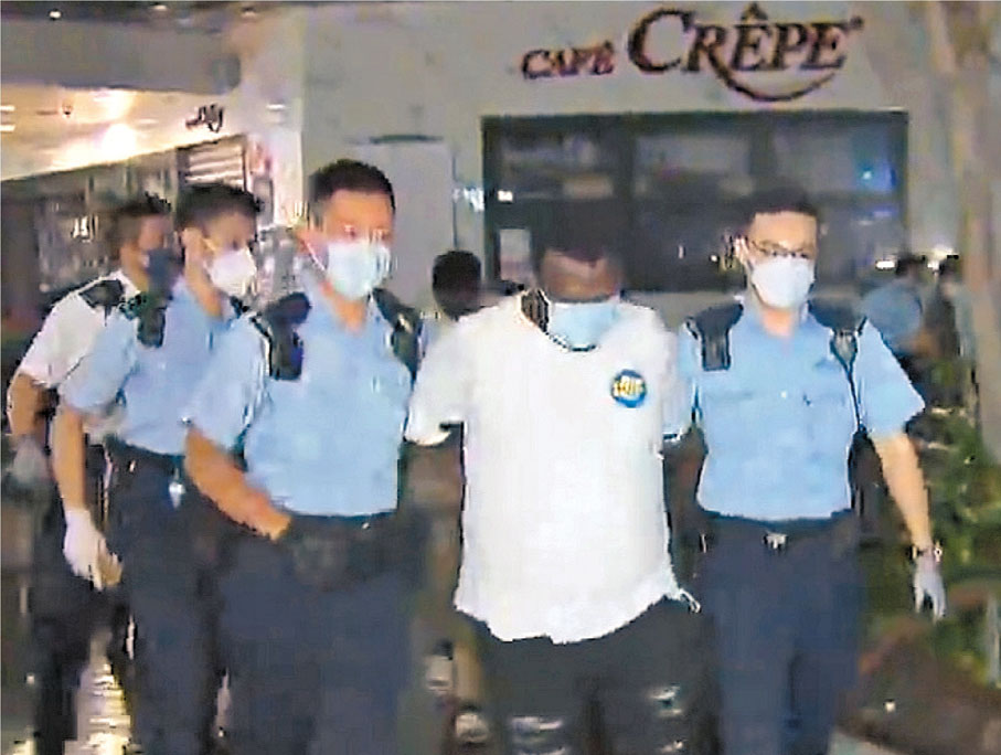 ◆警員將涉嫌毆劫非華裔婦人的非洲裔男劫匪帶署扣查。電視截圖