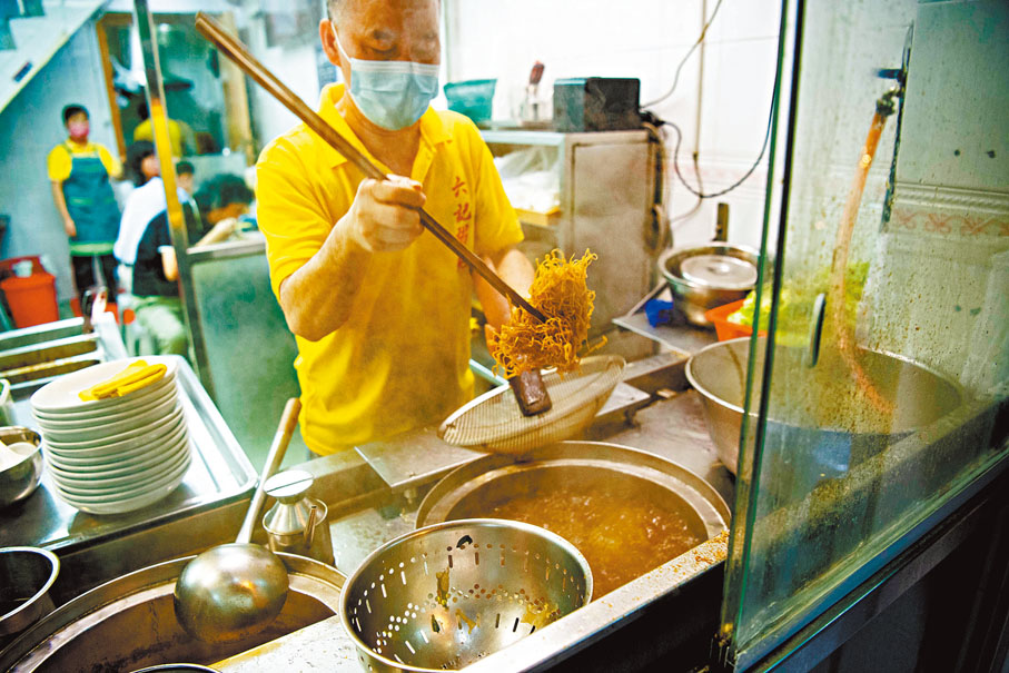 ◆「六記粥麵」的師傅將竹昇麵抖落下鍋。 新華社