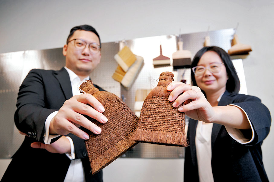 ◆香港故宮文化博物館兩位藏品修復主任梁嘉放（右）及呂智超（左）手持修復文物的工具「棕刷」合影。 港故宮館供圖