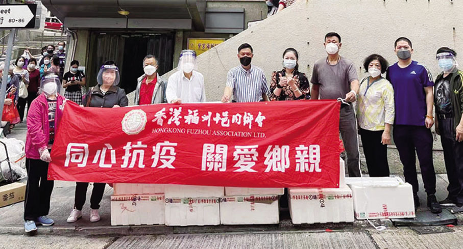 ◆ 陳治林（左五）與骨幹義工在西環正街派發新鮮蔬菜。