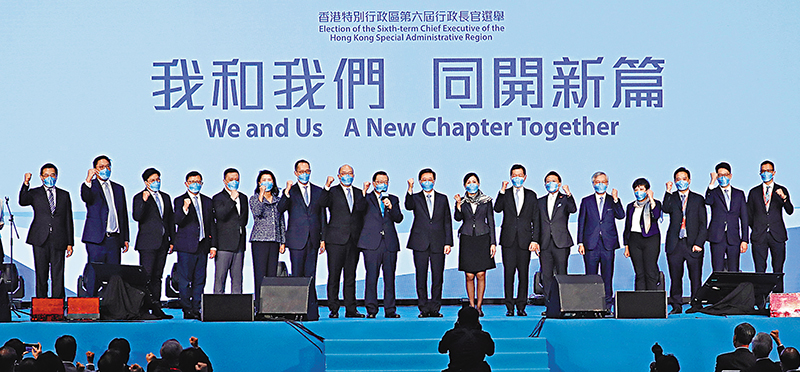 ◆李家超率領競選辦要員上台造勢。    香港文匯報記者 攝