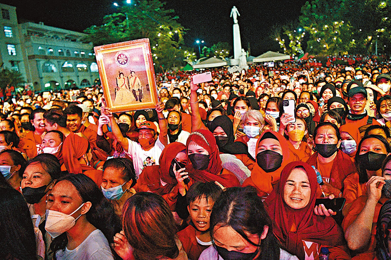 ◆小馬科斯支持者舉起其家族肖像。 法新社