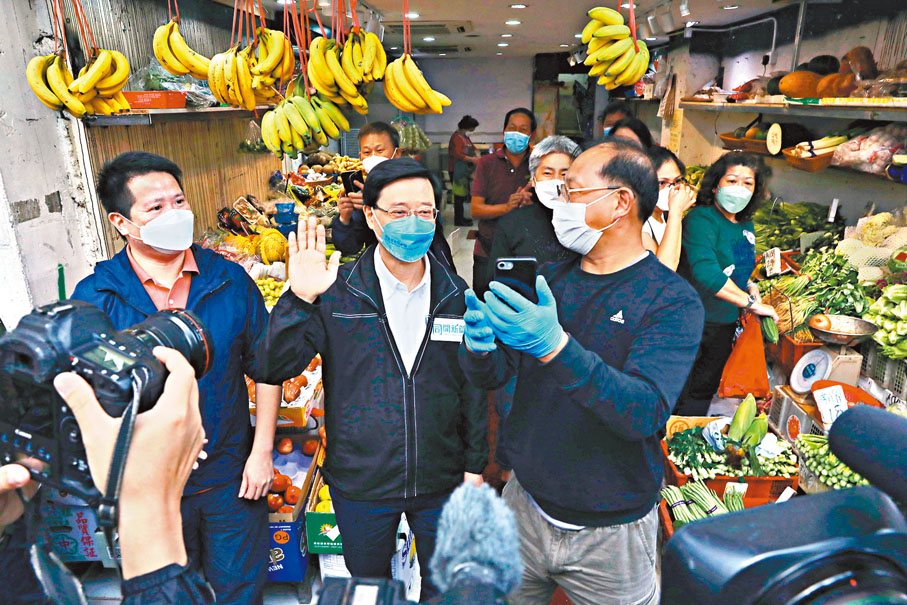 ◆李家超早前到香港仔落區受到附近街坊支持，圖為一名鮮果店店員自拍與李家超合影。 資料圖片