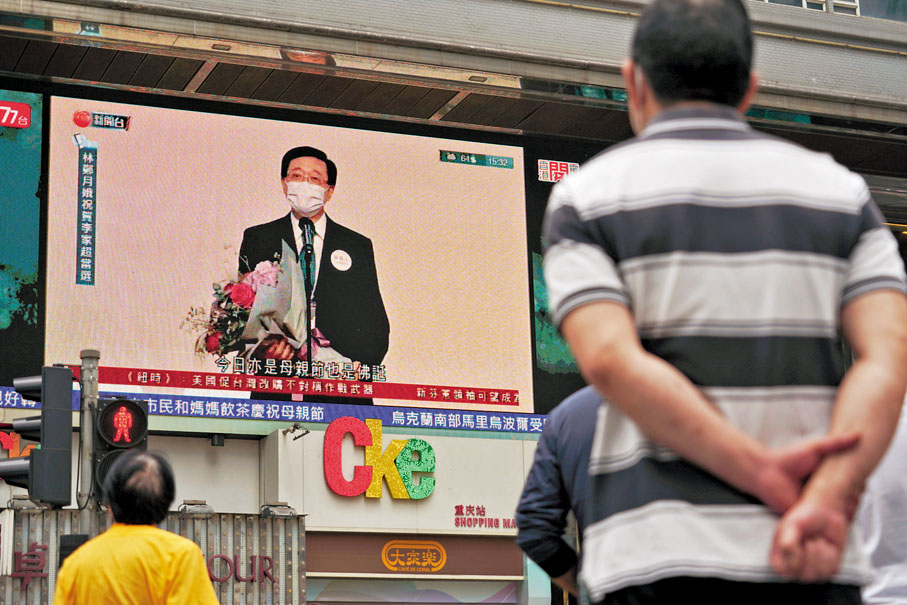 ◆ 市民在街頭觀看大電視，見證李家超以1,416票當選為香港特區第六任行政長官人選。 香港文匯報記者  攝