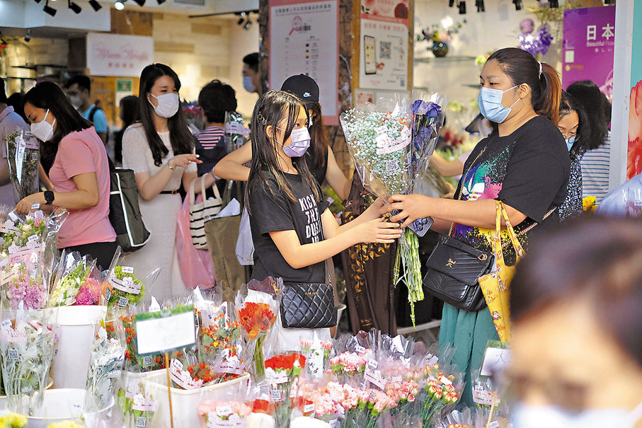 ◆小朋友往花墟買花贈媽媽，希望製造驚喜。香港文匯報記者 攝