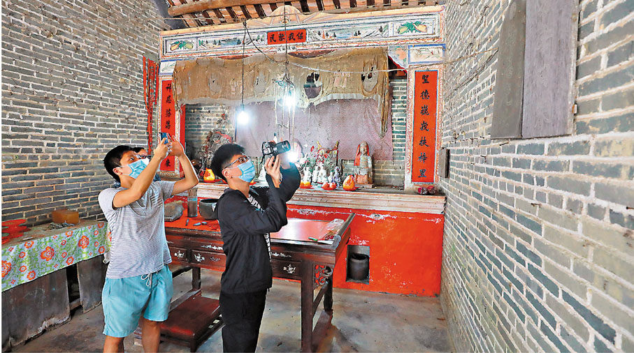 ◆90後研究人員許家明及余嘉浩（右），以拍照記錄打鼓嶺歷史建築物的細節。 香港文匯報記者  攝