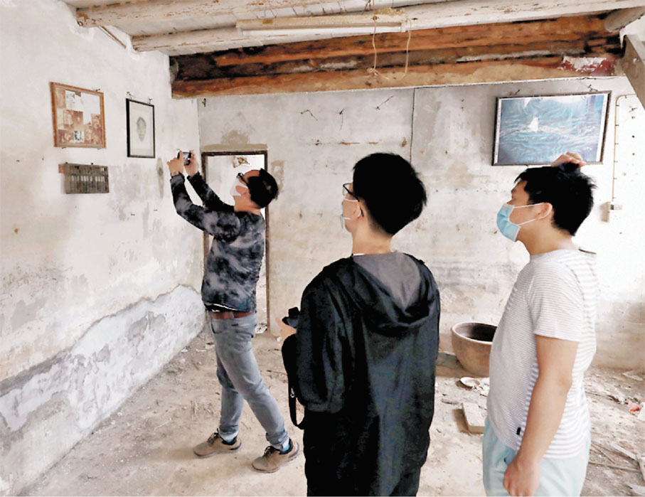 ◆鄉志團隊仔細記錄打鼓嶺建築物內一些歷史物件。 香港文匯報記者  攝